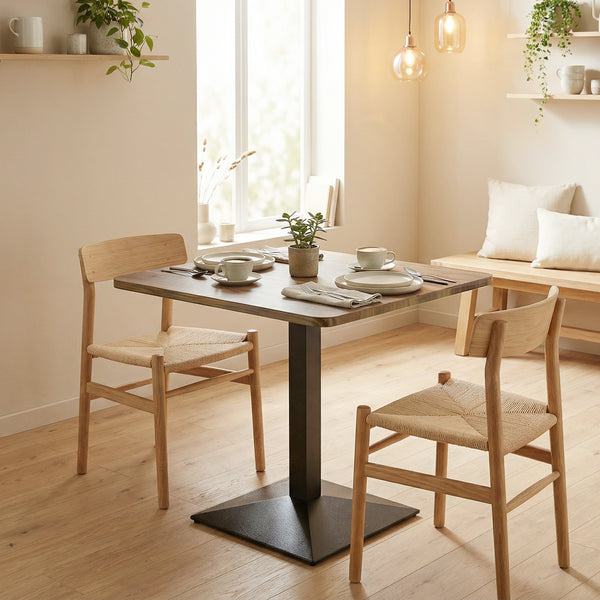 Table de salle à manger carrée avec piètement en acier, compacte et peu encombrante, aspect noyer.