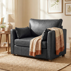 Faux leather accent chair with wide seat, spring cushion, rubberwood legs, 2 pillows, black